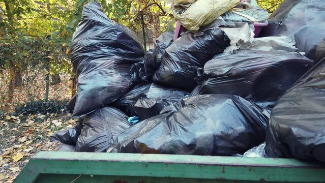 Stacks of litter bags overflow trash cans after festival in a city