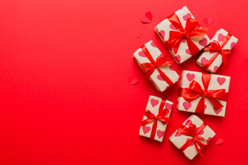 Top view photo of valentine day decorations gift box with red ribbon bow on colored background. Holiday gift boxes with top view