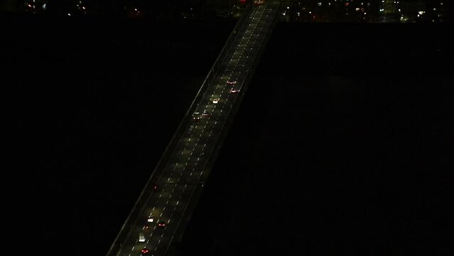 aerial view of Highway bridge in a pitch black surrounding. Traffic at night 