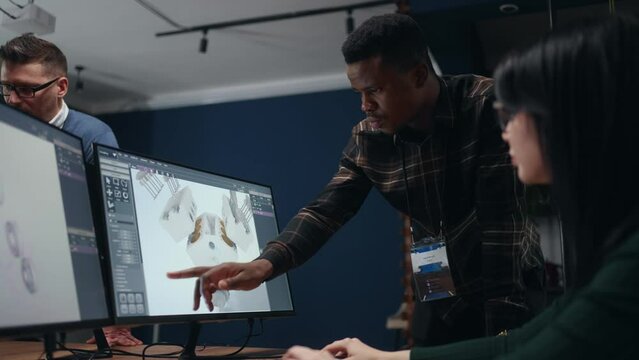 projecting engine for new car or spaceship, engineers use CAD program, looking 3D model on display