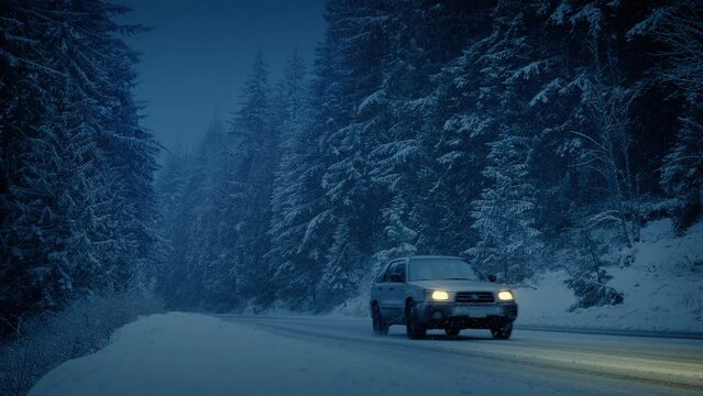 Car And Truck Drive Past On Snowy Mountain Road In The Dark