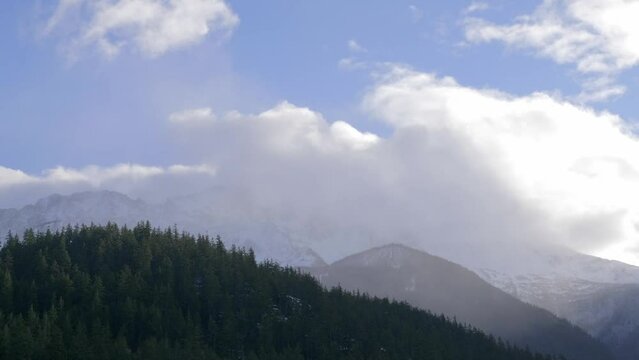 Fluffy Cloudscape Over Misty Mountains With Conifer Trees. Static Shot