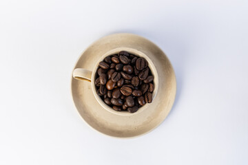 Toned brown cup with coffee beans inside. Top view
