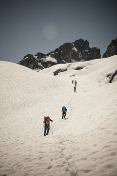 Six climbers cross a snow patch en route to climb Trio Peak in British Columbia, Canada.