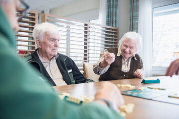 Senior inhabitants playing board game in rest home