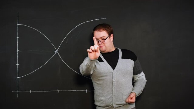 Professor teaches activity planning and draws point at intersection of two curved lines on graph. Topic of training in trading and survival in crisis situations. Presentation on subject of economics