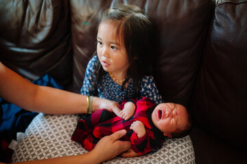 moment of an asian family at home with a crying newborn baby