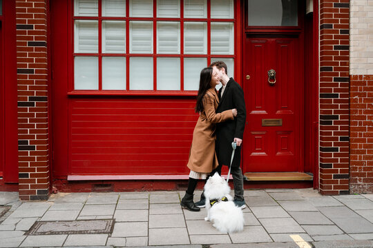 Happy lovers with their dog have fun outdoor