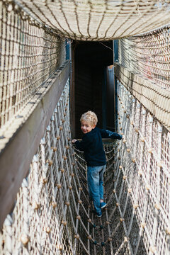 Boy standing on a rope bridge