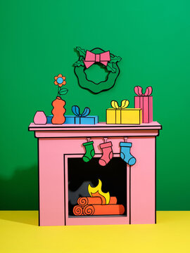 Paper cut  fireplace, and gift decorated by socks raster on green