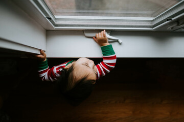 Toddler looking out a window 