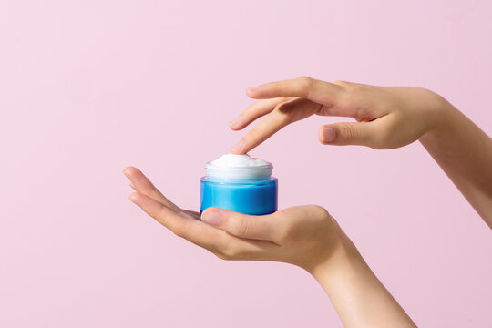 Skin care product. Female hand holding a face cream jar