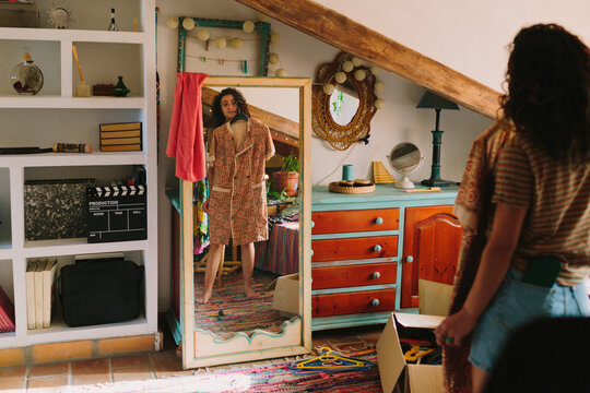 Woman looking her outfit in front of a mirror