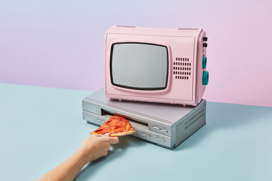 TV, female hand inserting pizza in VCR player. Blast of the past