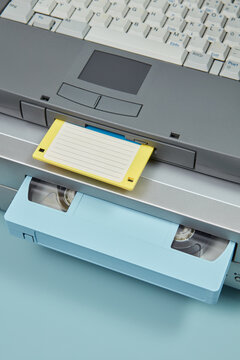 Old laptop with floppy disk, VCR with cassette.