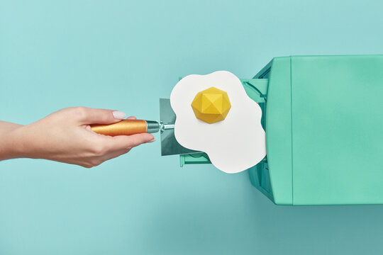 Paper egg placed by woman in CD drive.