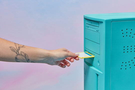 Floppy disk placed by female hand in computer.