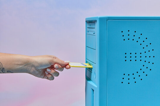 Floppy disk inserted by hand in computer.