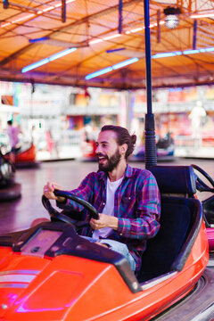 Happy man driving bumper car