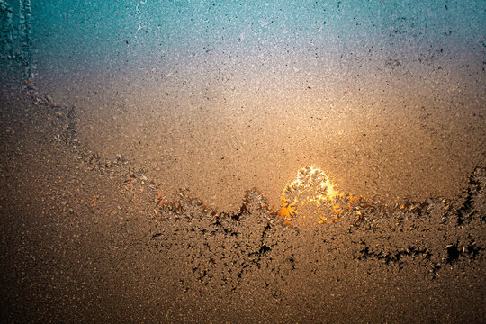 Colorful sunset shot through a frosty window