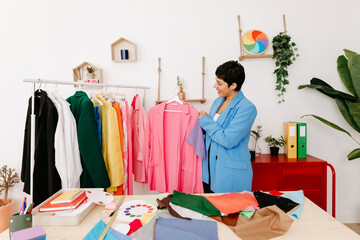Hispanic fashion blogger examining clothes on rail