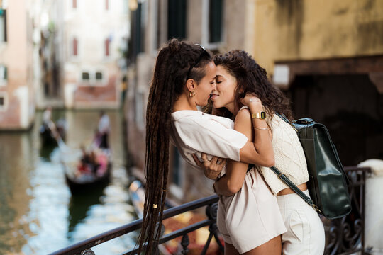Lesbian couple kissing on a bridge in Venice