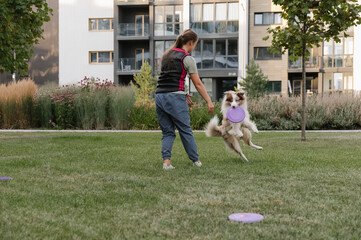 Woman teaching dog to catch frisbee