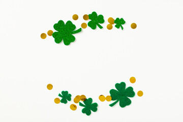 St Patrick's Day concept. Creative layout with frame of four-leaf clover and gold coins on white...
