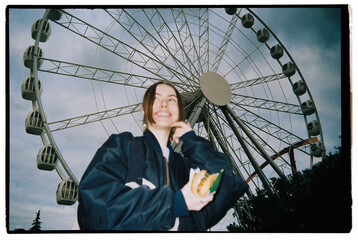 woman in the amusement park with hot dog in a hand
