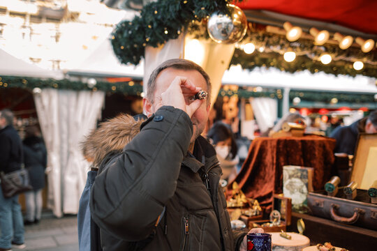Man on the Christmas Market checking out kaleidoscope 