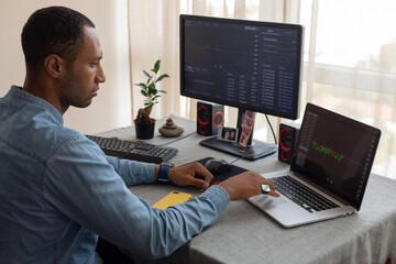 man working at home with two monitors