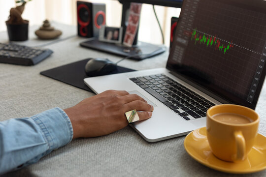 a man's hand with a ring on a laptop, in the frame a mug of coffee
