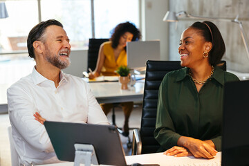 Cheerful diverse colleagues working on project in office
