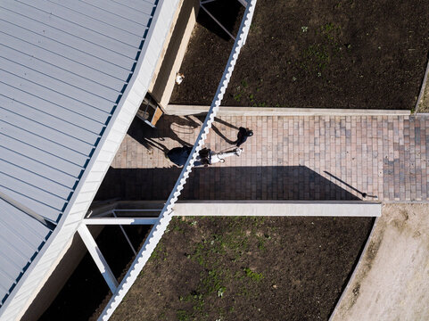 Aerial view of a young rider leaving the stables with his horse