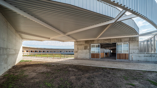 Front view of a modern circular design horse ranch at daylight