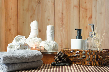 Fototapeta na wymiar Beautiful spa composition on white table with, spa herbal ball, towels and burning candles.