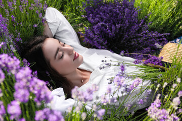 Young woman lying in lavender field on summer day © New Africa