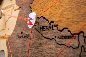 Nepal flag on the pushpin with red thread showed the paths of movement or areas of influence in the...