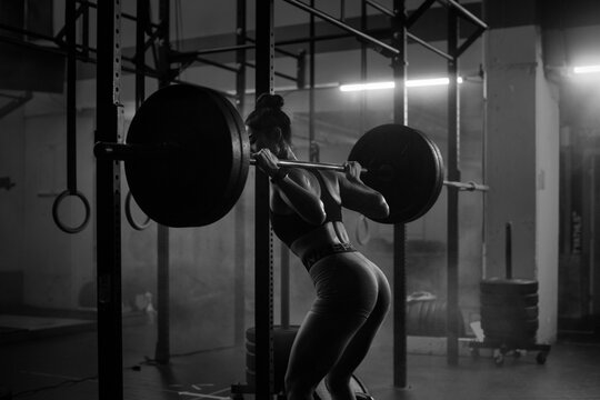 Young Asian female training in gym with weights at night
