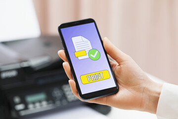 Man using printer management application on mobile phone indoors, closeup. Image on device screen.