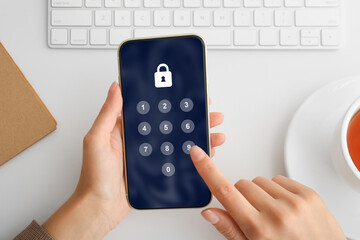 Privacy protection. Woman entering pin code on smartphone at white table, top view. Lock and numpad on screen
