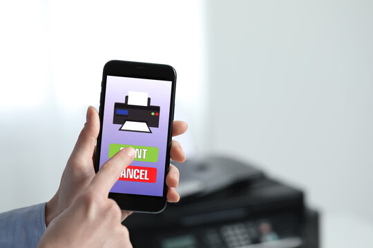 Man using printer management application on mobile phone indoors, closeup and space for text