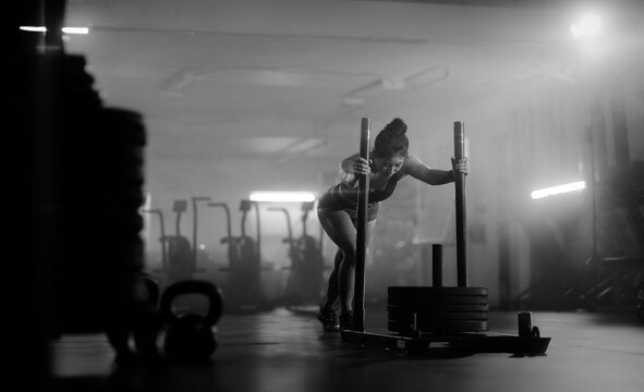 Young Asian female training in gym with weights at night