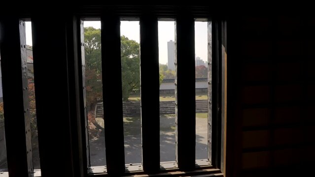 This panning vide shows a POV view of someone looking out of an old Japanese fort window.