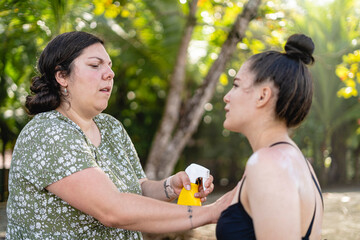 Women putting sunscreen on their skin