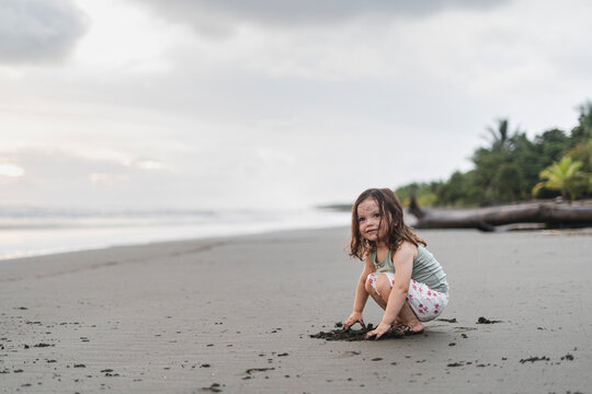 image of a girl playing in the sand 