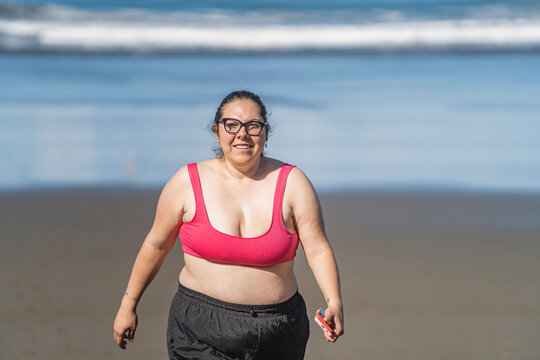 plus-size woman walking on the beach