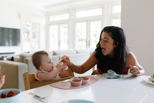 Mother feeds a baby at home