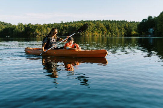 little boy in a kayak with his grandmother on a lake 