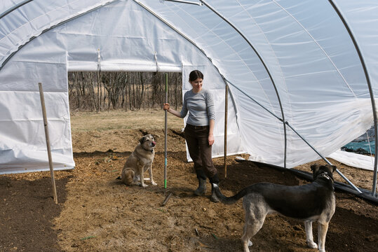 Flower Farmer in greenhouse playing with her dogs
